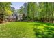 Expansive backyard featuring lush green lawn, mature trees, and stone retaining walls at 2890 Howell Mill Rd, Atlanta, GA 30327