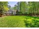 Expansive backyard with lush lawn, stone retaining wall, and mature trees at 2890 Howell Mill Rd, Atlanta, GA 30327