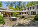 A backyard has manicured landscaping, a dining table, and a fireplace with seating at 2890 Howell Mill Rd, Atlanta, GA 30327