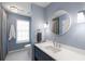 Well-lit bathroom with a stylish round mirror, modern lighting, and a blue vanity at 2890 Howell Mill Rd, Atlanta, GA 30327