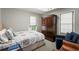 Bedroom features a bed with patterned bedding, a dark wood armoire, and a sitting area at 2890 Howell Mill Rd, Atlanta, GA 30327