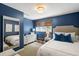 Inviting bedroom with blue walls, a large mirror, and soft bedding, providing a serene and restful ambiance at 2890 Howell Mill Rd, Atlanta, GA 30327