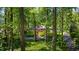 View of a charming home surrounded by mature trees, lush landscaping, and a circular driveway at 2890 Howell Mill Rd, Atlanta, GA 30327
