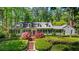 Charming home with a manicured front lawn, mature trees, and traditional architectural details at 2890 Howell Mill Rd, Atlanta, GA 30327