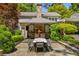 An outdoor fireplace has a seating area and dining table, offering an excellent entertaining area at 2890 Howell Mill Rd, Atlanta, GA 30327