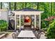 A lovely outdoor kitchen and dining area featuring stainless appliances, a large table, and beautiful natural surroundings at 2890 Howell Mill Rd, Atlanta, GA 30327