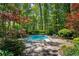 Backyard pool surrounded by lush landscaping and stone patio with lounge chairs at 2890 Howell Mill Rd, Atlanta, GA 30327