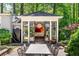 View of the pool house with full glass doors, outdoor dining area, and lush landscaping at 2890 Howell Mill Rd, Atlanta, GA 30327