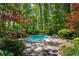 An inviting pool surrounded by lush landscaping, stone tile, and mature trees at 2890 Howell Mill Rd, Atlanta, GA 30327