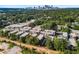 Aerial view of a modern townhome community with lush green surroundings and distant skyline views at 383 Grant Se Cir # 1634, Atlanta, GA 30315