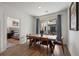Modern dining room with wood floors, large windows, and access to balcony with a peek into the main bedroom at 383 Grant Se Cir # 1634, Atlanta, GA 30315