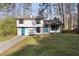 Charming split level home with a well-manicured lawn and a welcoming, bright blue front door at 3840 Natalie Way, Ellenwood, GA 30294