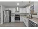 Modern kitchen boasts stainless steel appliances, granite countertops and sleek, white cabinetry at 3840 Natalie Way, Ellenwood, GA 30294