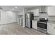 Modern kitchen boasts stainless steel appliances, granite countertops and sleek, white cabinetry at 3840 Natalie Way, Ellenwood, GA 30294