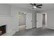 Bright living room with a ceiling fan and a gray fireplace, with view of the backyard through the doorway at 3840 Natalie Way, Ellenwood, GA 30294