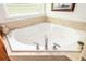 Close-up of a large corner tub with tile surround and chrome fixtures at 690 Sienna Dr, Cumming, GA 30040