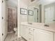 Bathroom featuring white cabinets, double sinks, and a decorative shower curtain at 690 Sienna Dr, Cumming, GA 30040