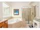 Bright bathroom featuring a corner tub and a shower with glass doors at 690 Sienna Dr, Cumming, GA 30040