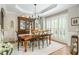 Elegant dining room showcasing a large wooden table, modern chandelier, and shuttered windows at 690 Sienna Dr, Cumming, GA 30040