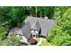 Aerial view of a gray roofed home surrounded by lush greenery, showcasing the property's privacy and curb appeal at 1595 Northcliff Trce, Roswell, GA 30076