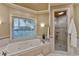 Well-lit bathroom with soaking tub, walk-in shower, and a large window for natural light at 1595 Northcliff Trce, Roswell, GA 30076