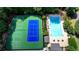Overhead capture of two tennis courts and a pristine swimming pool, surrounded by trees, perfect for active homeowners at 1595 Northcliff Trce, Roswell, GA 30076