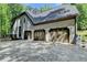 Rear exterior view with three-car garage showing ample parking and storage at 1595 Northcliff Trce, Roswell, GA 30076