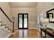 Welcoming foyer featuring hardwood floors, staircase with white railing, and striking entry door with intricate details at 1595 Northcliff Trce, Roswell, GA 30076