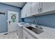 Laundry room features a stainless steel sink, granite countertops, white cabinets, and a washer and dryer at 1595 Northcliff Trce, Roswell, GA 30076