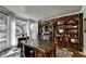 Office with a large wooden bookcase wall, desk, and a window with sheer curtains at 1595 Northcliff Trce, Roswell, GA 30076