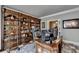 An office features a large wooden bookcase wall, desk, and leather chair at 1595 Northcliff Trce, Roswell, GA 30076