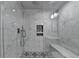 Luxurious walk-in shower with elegant tiling, a built-in bench, and modern fixtures at 1595 Northcliff Trce, Roswell, GA 30076