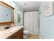 Well-lit bathroom featuring a wood vanity, a large mirror, and a tiled shower at 1721 Mulberry Lake Dr, Dacula, GA 30019