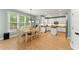Bright eat-in kitchen features a hardwood floor, white cabinets, stainless appliances, and a light-filled dining area at 1721 Mulberry Lake Dr, Dacula, GA 30019