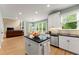 Well-lit kitchen with stainless steel appliances, white cabinets, island, and an adjoining dining area at 1721 Mulberry Lake Dr, Dacula, GA 30019