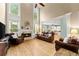 Bright living room with fireplace, hardwood floors, tall windows, and comfortable leather seating at 1721 Mulberry Lake Dr, Dacula, GA 30019