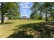 A large backyard with a well-kept lawn, framed by mature trees, offering a peaceful outdoor space at 282 Oak Rdg, Auburn, GA 30011