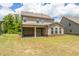 View of the home's backyard with covered patio and lush green lawn at 3477 Ivy Birch Way, Buford, GA 30519