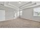 Spacious bedroom featuring tray ceilings, neutral walls, plush carpet, and plenty of natural light at 3477 Ivy Birch Way, Buford, GA 30519