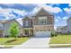 Attractive two-story home with stone accents, a green lawn, and a two-car garage, set against a bright sky at 3477 Ivy Birch Way, Buford, GA 30519