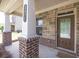 Inviting covered front porch with stone and brick accents and pillars, creating a welcoming entry to this lovely home at 3477 Ivy Birch Way, Buford, GA 30519