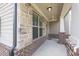 Covered front porch with stone accents, offering an inviting entrance and charm with brick accents at 3477 Ivy Birch Way, Buford, GA 30519