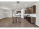 Open-concept kitchen featuring stainless steel appliances, granite countertops, dark wood cabinets, and an island at 3477 Ivy Birch Way, Buford, GA 30519