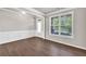 Bright living room featuring beautiful wood floors, ample natural light, and an inviting open layout, enhanced by white trim at 3477 Ivy Birch Way, Buford, GA 30519
