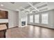 Cozy living room featuring a fireplace, tray ceiling, hardwood floors, and large windows for natural light at 3477 Ivy Birch Way, Buford, GA 30519