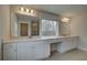Bathroom with double vanity, white cabinets, and tile flooring at 4032 Andover Cir, Mcdonough, GA 30252