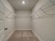 Empty walk-in closet features wire shelving and neutral carpeting at 4032 Andover Cir, Mcdonough, GA 30252