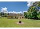 Expansive backyard featuring a fire pit, a lush lawn, and mature trees at 265 Oak Hill Dr, Covington, GA 30016