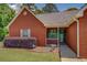 Inviting brick home with a covered front porch and landscaped garden bed at 265 Oak Hill Dr, Covington, GA 30016