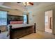 Spacious main bedroom with a large dark-stained bedframe and decorative ceiling fan at 265 Oak Hill Dr, Covington, GA 30016